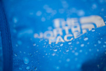 blue fabric with water droplets and the north face logo